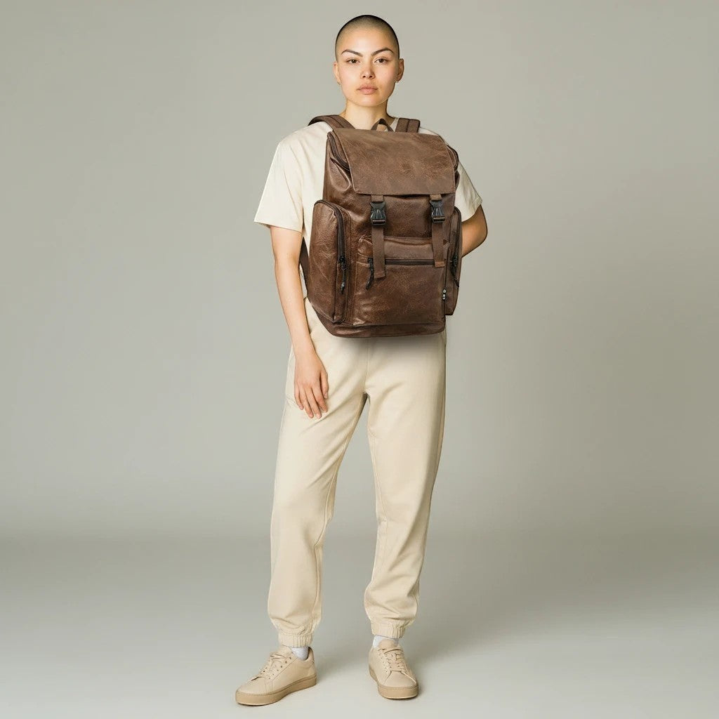 Osoba nosząca brązowy plecak SchoolKit w stylu retro z matowej eko-skóry z regulowanymi szelkami i klamrami.